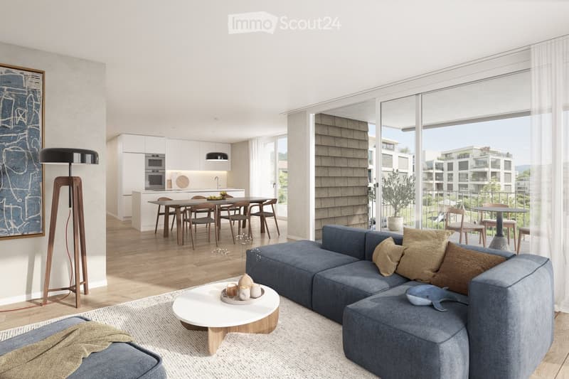 Modern living and dining area with a blue sectional sofa, coffee table, floor lamp, dining table with chairs, and a kitchen area with cabinets and a microwave. Large windows offer a view of the outdoor area.