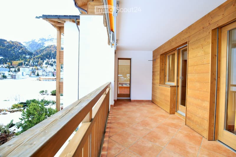 Balcony with wooden railing, tiled floor, and scenic mountain view.