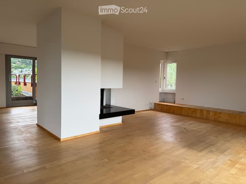 Unfurnished Room. Empty room with light wooden flooring, white walls, and large windows allowing natural light. Features a fireplace and a built-in bench along one wall.