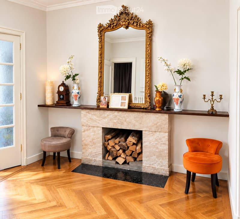 Elegant living room with a marble fireplace, two plush stools, ornate mirror, decorative vases, and a candle holder on the mantel.
