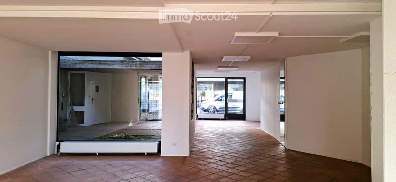 empty hallway, terracotta tiles, large windows, sliding glass door, white walls, lights on ceiling