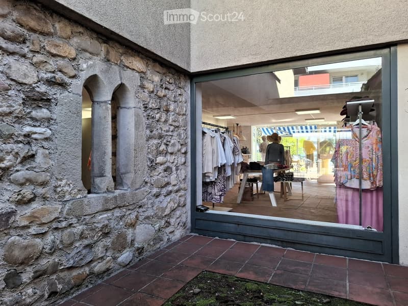 Stone wall, metal framed glass door, clothing displays