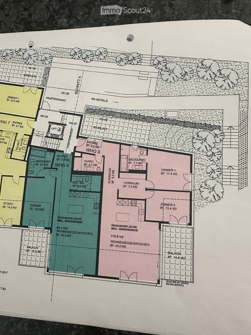 Floor plan showing multiple apartments with labeled rooms including living/dining/kitchen areas, bedrooms, bathrooms, balconies, and entrances.