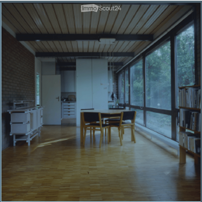Bright, minimalist dining area with wooden flooring, large windows, a dining table with chairs, a kitchen cabinet, and a bookshelf.