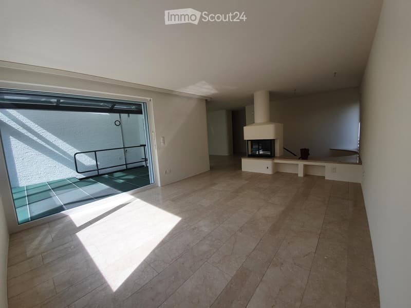 Empty room with tiled floor, large window, fireplace, and bench seating area.