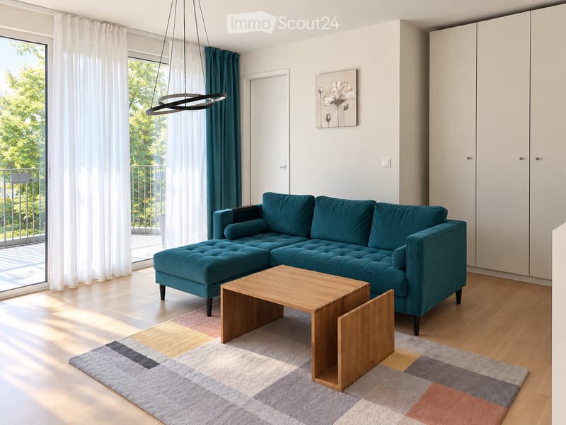 Modern living room with a teal sectional sofa, wooden coffee table, colorful rug, large windows with white curtains, and a balcony view.