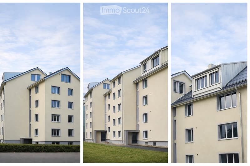 Apartment building with many windows, beige exterior, two entrances on the left, a grassy area in the middle