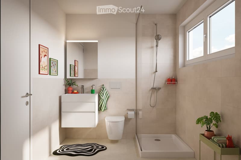 Modern bathroom with a white sink, mirror, toilet, and shower. Features include a green towel, small plant, picture frames, and a black and white rug.