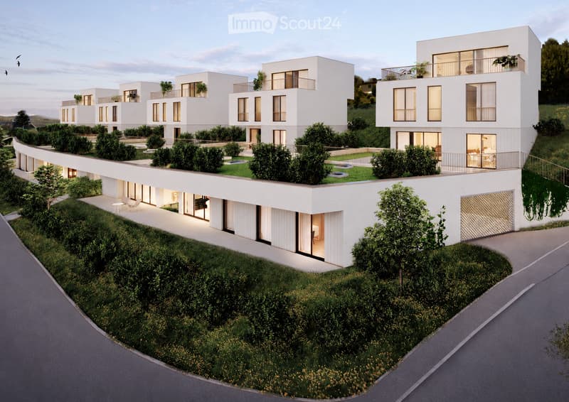 Modern multi-unit residential building with white facades, large windows, balconies, and landscaped surroundings.