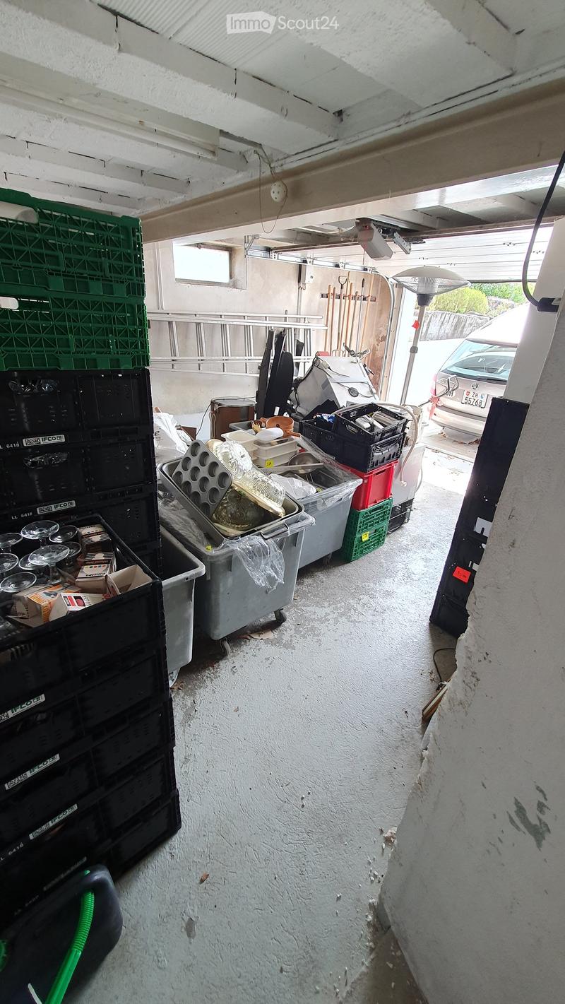 {"visible_features": ["Garage"], "type": "Garage", "objects": [], "description": "Garage with various stored items including crates, boxes, and a car partially visible through the open door.", "localized_descriptions": {"EN": "Garage with various stored i