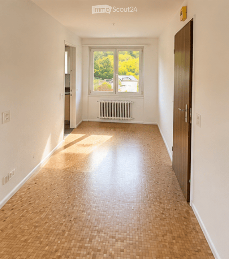 Empty room with light wooden flooring, white walls, and a large window with a view of greenery. No furniture or equipment present.