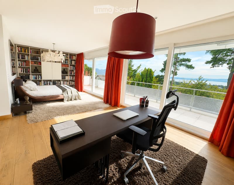 Modern bedroom with a large bed, desk, and bookshelf, featuring large windows with a scenic view of the landscape.