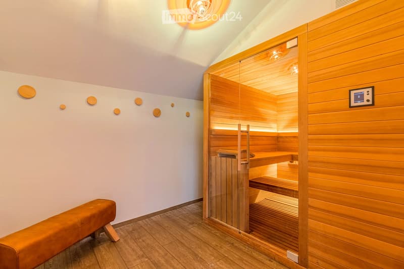 Spa room with a wooden sauna, glass door, wooden benches, and a control screen.
