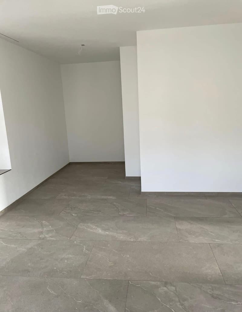 Empty room with light-colored walls and a polished marble tile floor. No furniture or equipment is present.