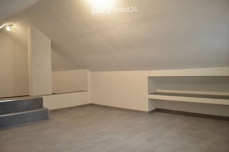 Empty room with tiled floor, white walls, built-in shelving unit, and a small staircase leading up.