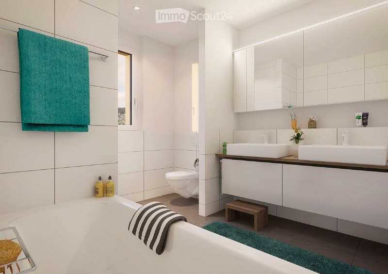 Modern bathroom with white tiles, a bathtub, toilet, double sink, mirrored cabinet, and a small wooden stool. Green towels and a striped towel are placed on the edge of the bathtub and near the sink.