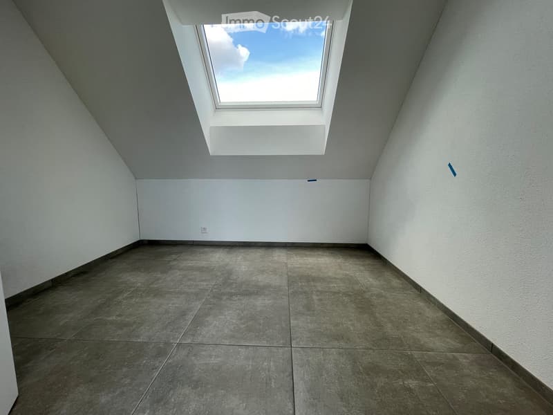 Empty room with white walls, concrete floor, and a skylight window at the top.