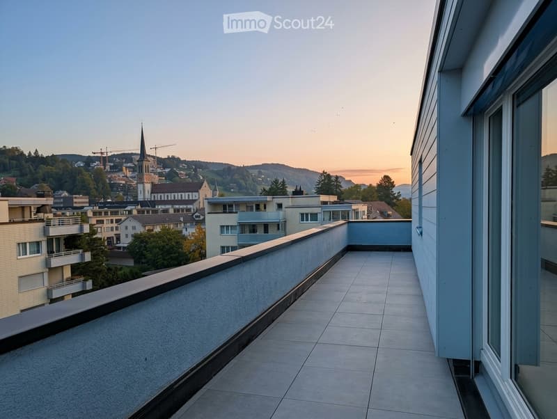 Balcony with tiled floor, low railing, and a panoramic view of a town with buildings, trees, and a church spire in the distance.