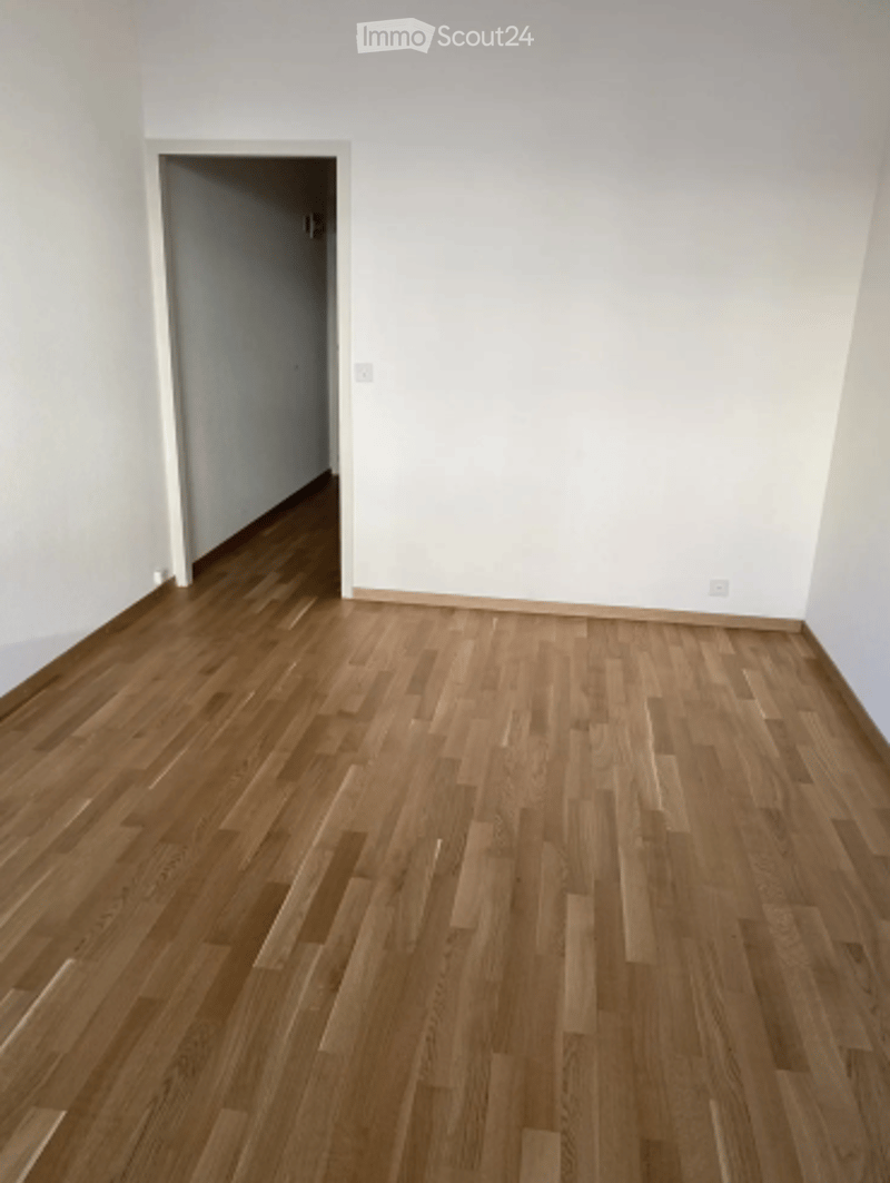 Completely empty room with bare white walls and wooden floor. No furniture or equipment.