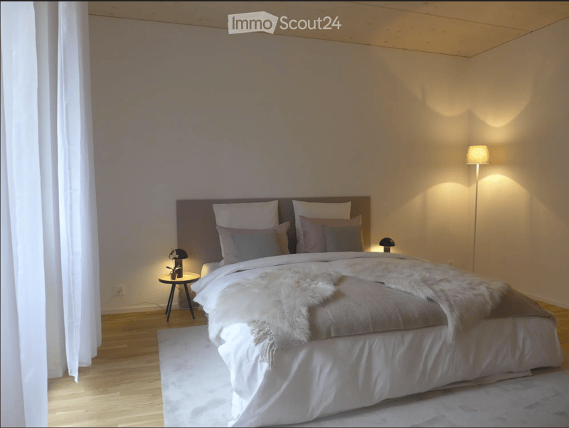 Modern bedroom with a large bed, nightstands, floor lamp, and a fur throw on the bed.