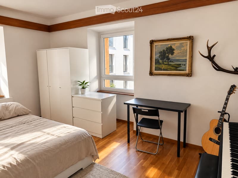 Bright bedroom with wooden flooring, a single bed, a white wardrobe, a desk with a chair, a guitar, a small piano, a potted plant, and a framed painting on the wall.
