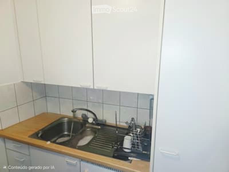 Modern kitchen with white cabinets, wooden countertop, and stainless steel sink.