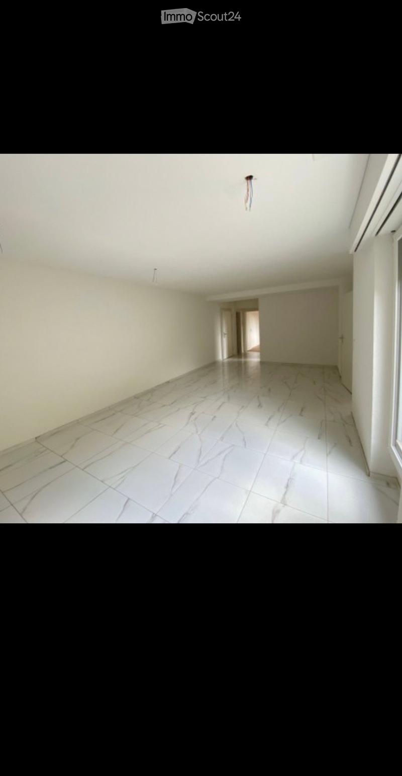 Empty hallway with white walls, marble flooring, and a ceiling light fixture. No furniture or equipment is present.