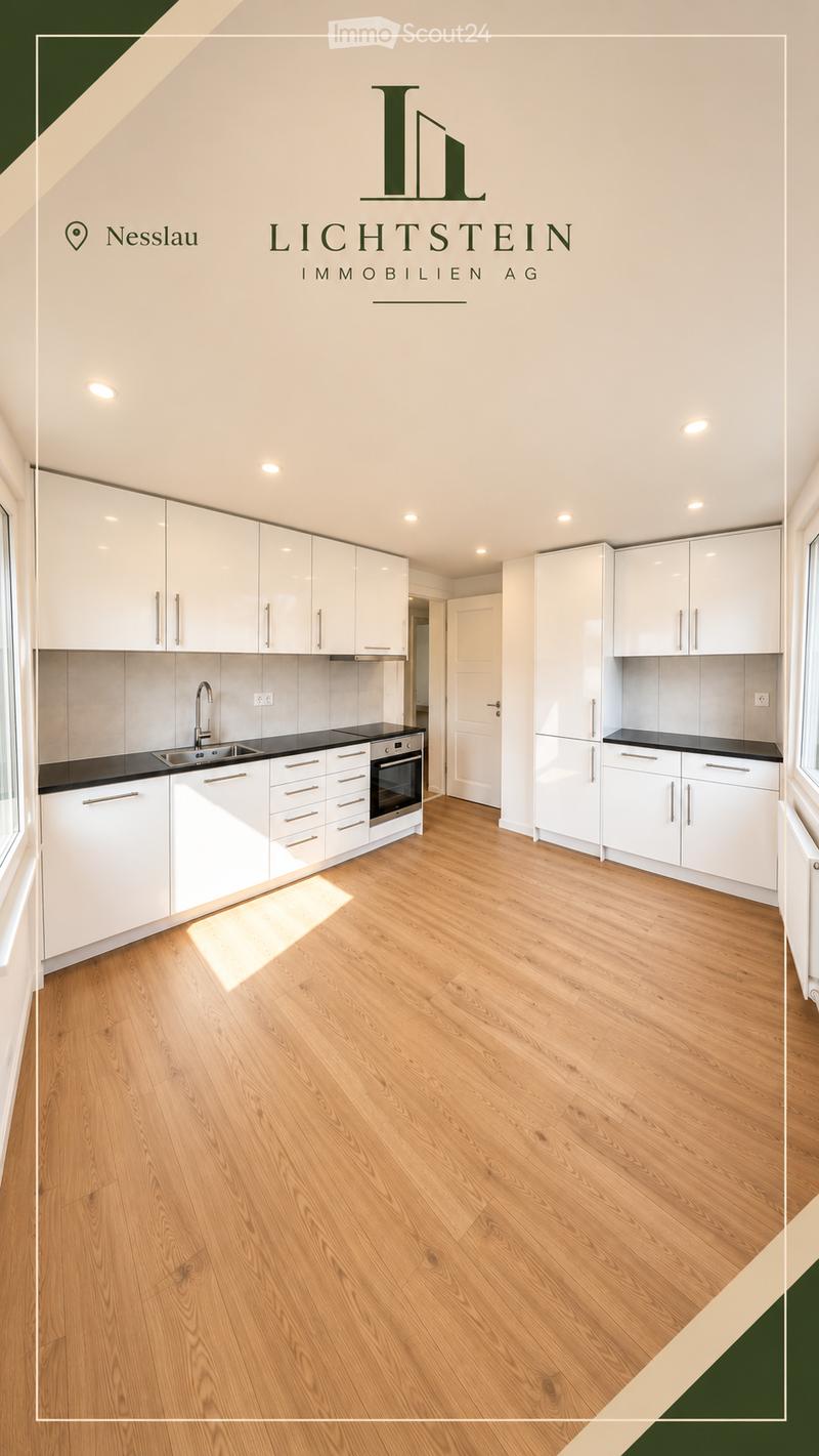 Modern kitchen with white cabinets, black countertops, wooden flooring, and integrated appliances including a sink, oven, and refrigerator.