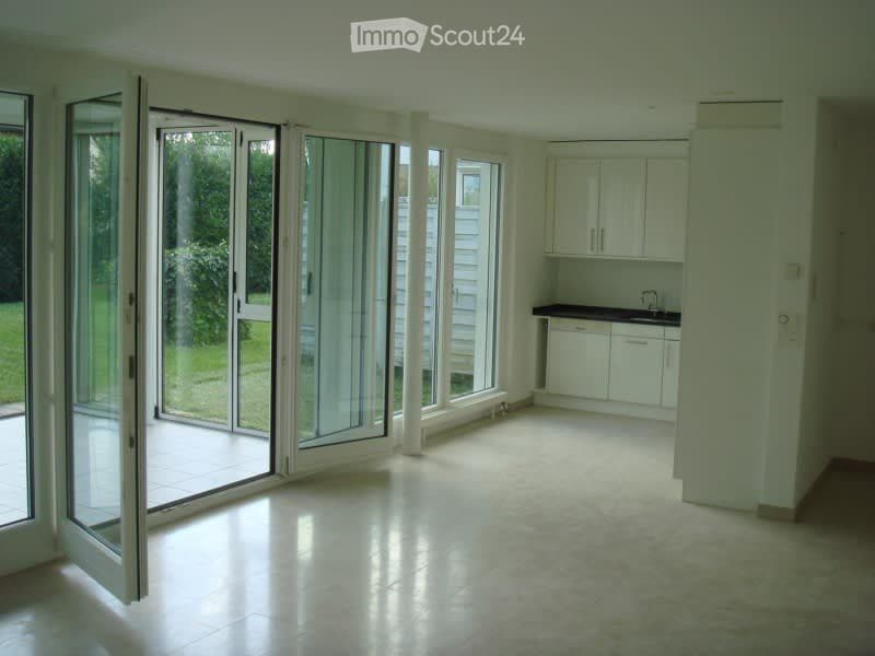 Bright, empty room with large sliding glass doors leading to a patio, white cabinetry, and a countertop.