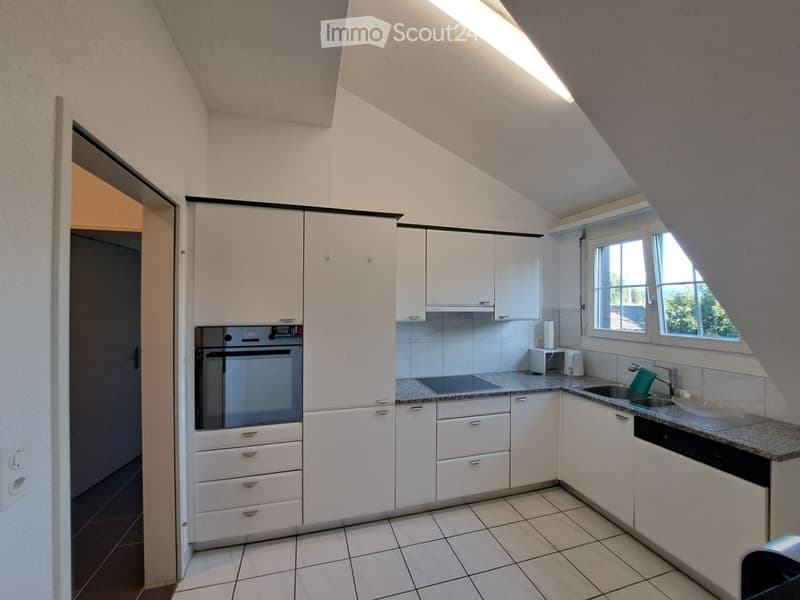 Modern kitchen with white cabinets, granite countertops, stainless steel appliances, and a window overlooking the outside.