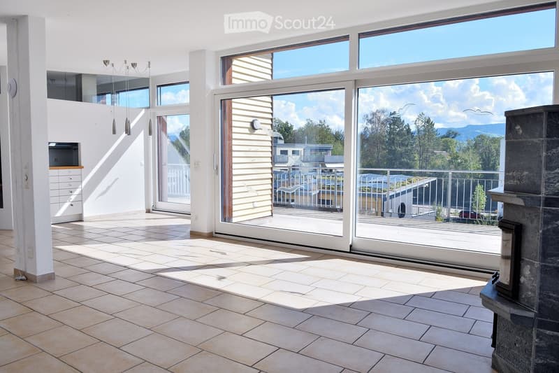 Bright, open living space with large glass doors leading to a balcony, tiled floor, fireplace, and built-in cabinetry.