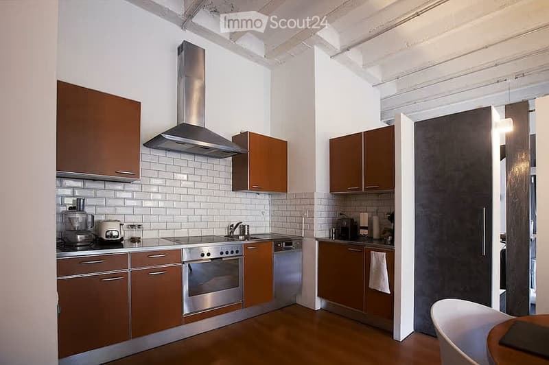 Modern kitchen with wooden cabinets, stainless steel appliances, white tiled backsplash, and a wooden floor.