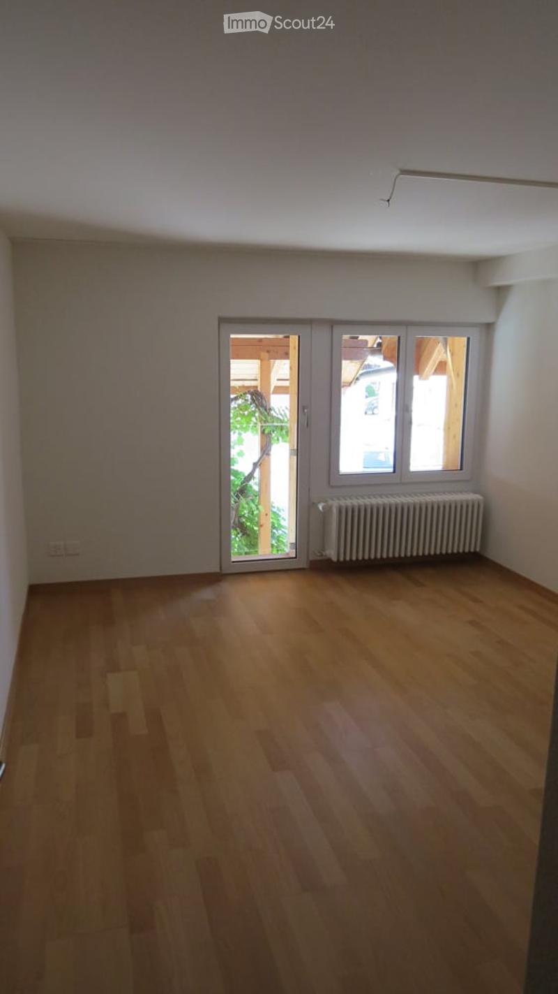 empty room, wooden floor, white walls, sliding doors, glass window, radiator, power outlet