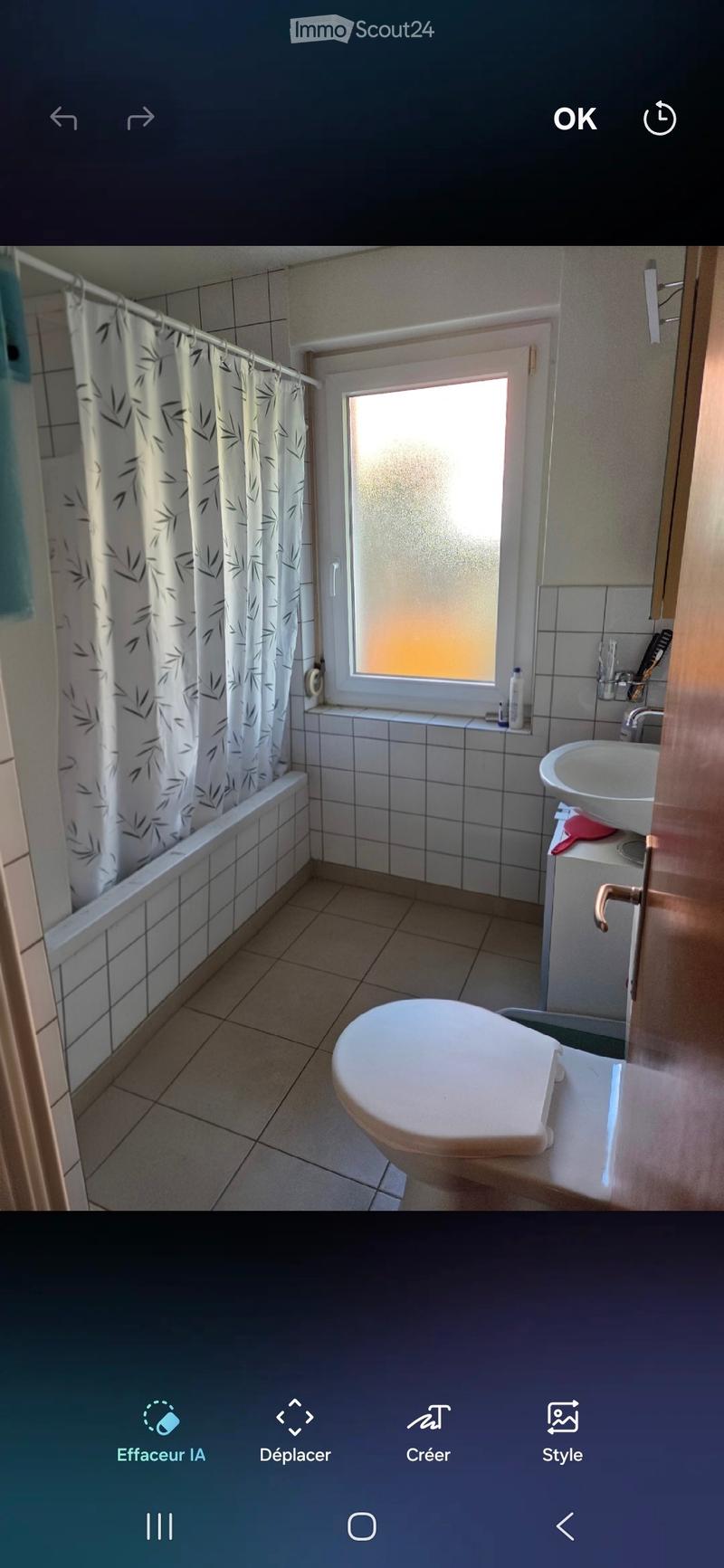 Bathroom with tiled walls and floor, bathtub, toilet, sink, and a frosted window letting in natural light.