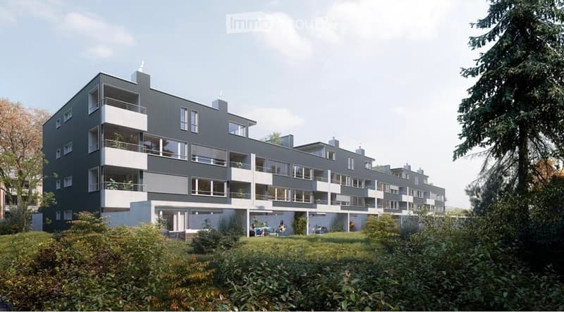 Modern multi-story apartment building with grey and white facade, multiple balconies, and surrounding greenery.