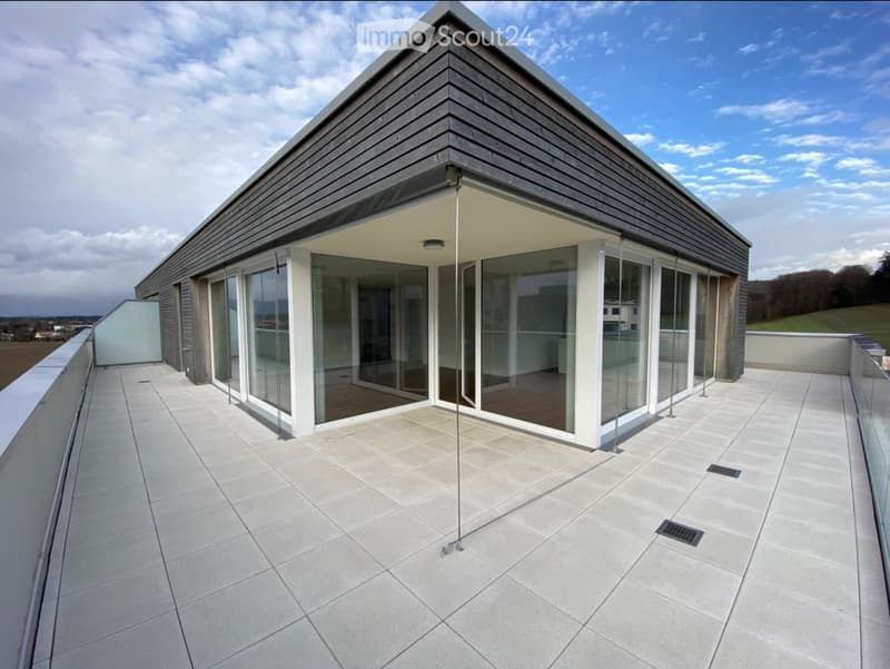 Modern rooftop terrace with large glass sliding doors, tiled floor, and a sleek, contemporary design.