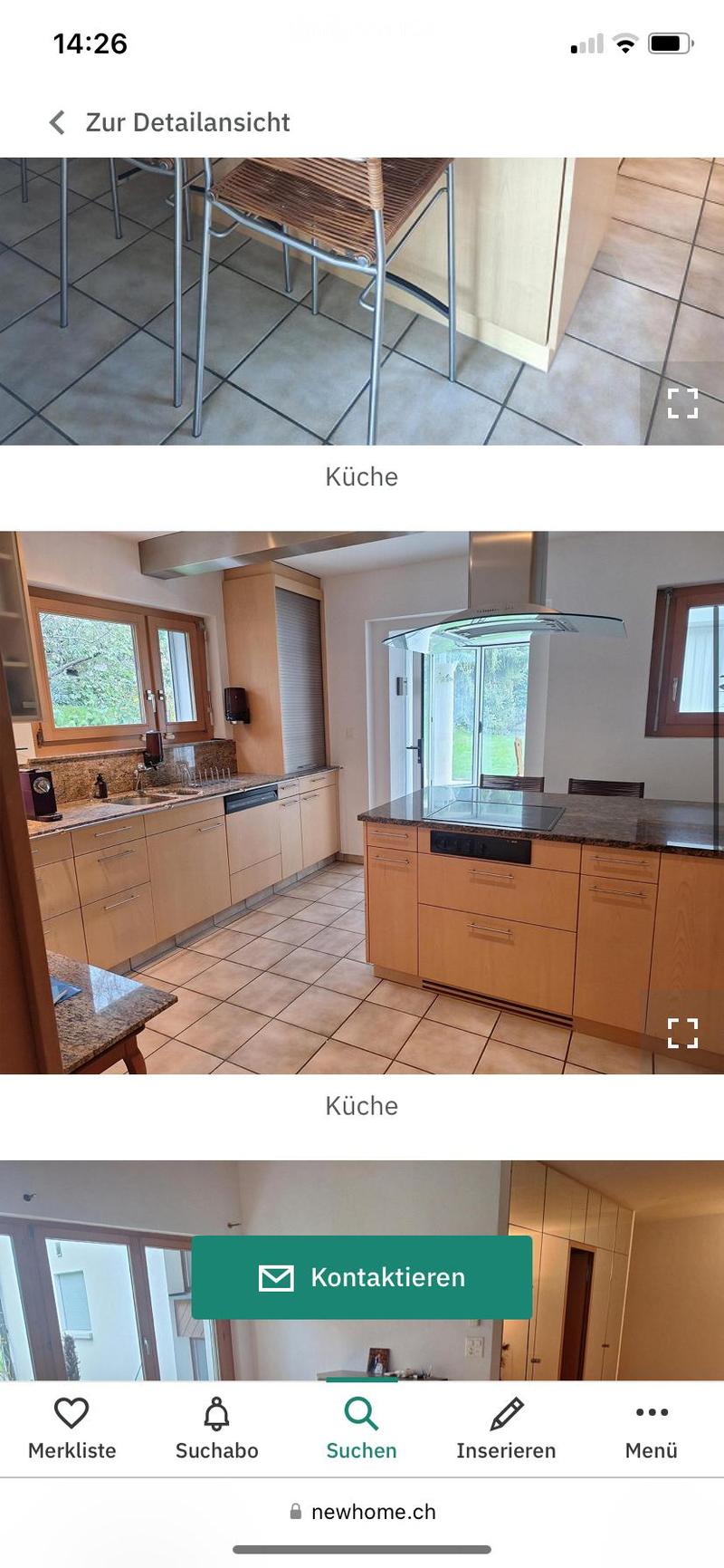 Modern kitchen with light wooden cabinets, granite countertops, stainless steel appliances, and a central island with bar stools.