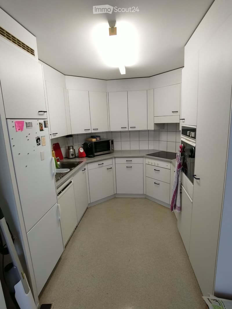 Modern kitchen with white cabinets, stainless steel appliances, and a clean, organized layout.