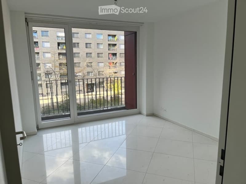 Empty room with white tiled flooring, large window with balcony access, and white walls.