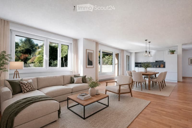Modern living and dining area with large windows, light-colored sofa, coffee table, dining table with chairs, and kitchen area with cabinets and pendant lights.