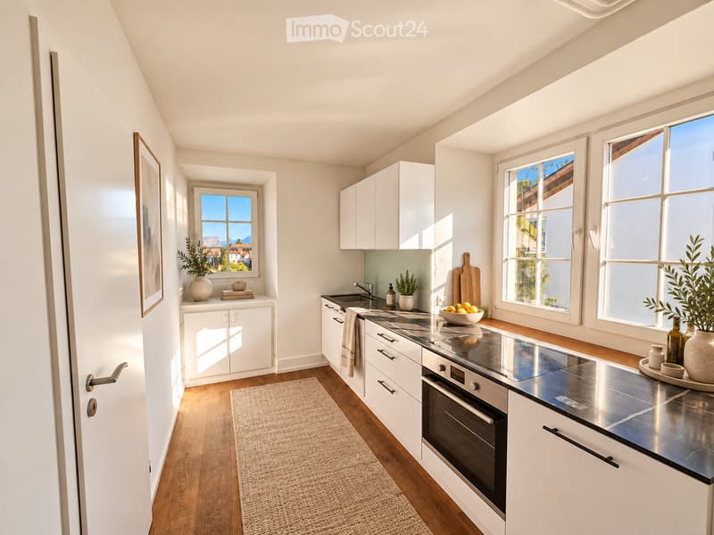 Modern kitchen with white cabinets, stainless steel appliances, wooden countertops, and large windows offering a view of the city.