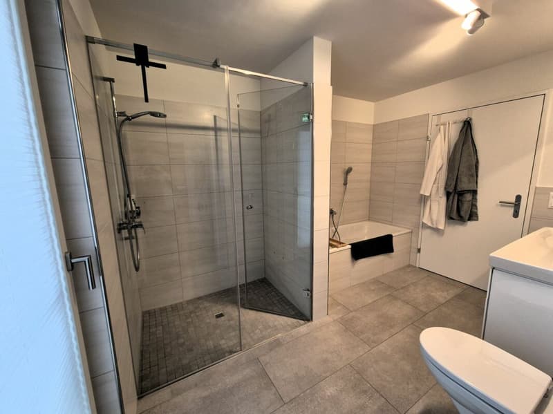 Badezimmer mit Badewanne und Dusche