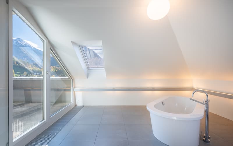 Badezimmer mit freistehender Badewanne und Zugang auf den Balkon...