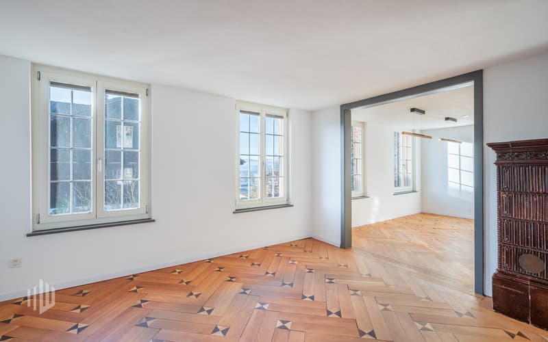Wohn- oder Essbereich mit Originalboden, Zugang in weiteres Zimmer