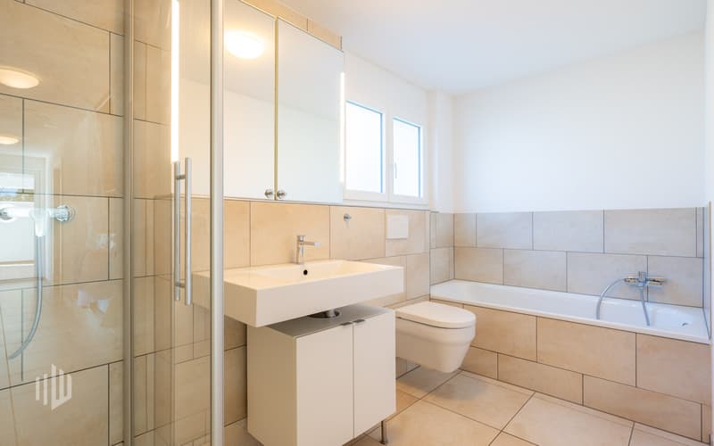 Badezimmer im Sockelgeschoss mit Dusche und Badewanne
