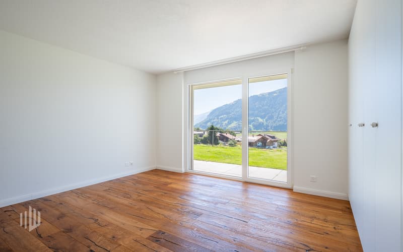 Zimmer 2 im Sockelgeschoss mit Einbauschrank, Zugang auf die Terrasse