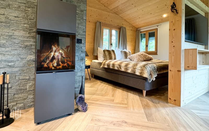 Sicht in den Schlafbereich, abgetrennt durch eine Holzwand