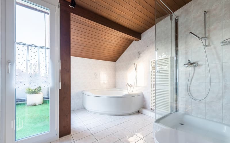 Badezimmer im Dachgeschoss mit Zugang auf den Balkon, Badewanne, Dusche und WC