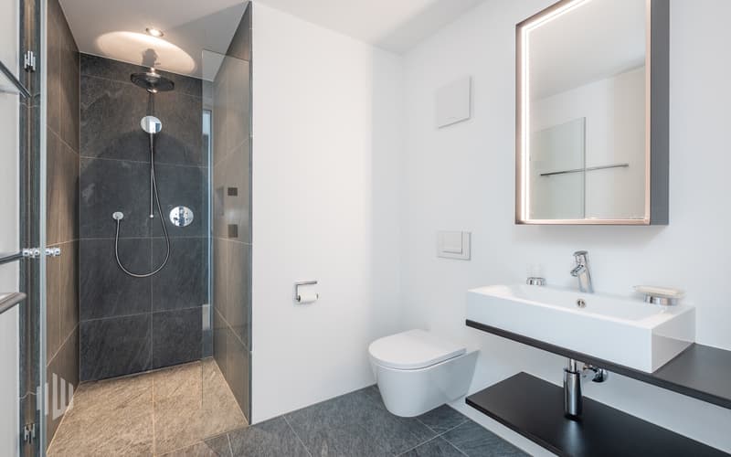 Zweites Dusch-Badezimmer mit Dusche und Toilette, ebenfalls mit Natursteinbelägen