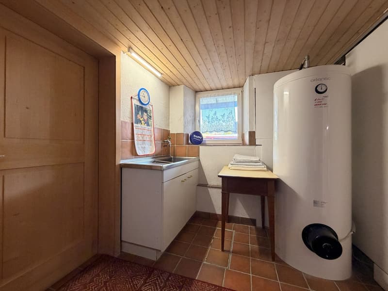 small room with sink, cabinets, and a water heater